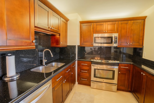 kitchen with backsplash, dark stone countertops, sink, and stainless steel appliances