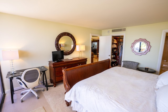 carpeted bedroom featuring a spacious closet and a closet