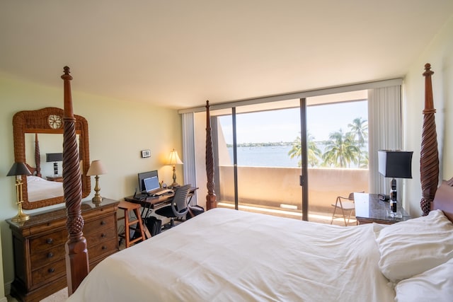 bedroom with access to exterior and a wall of windows