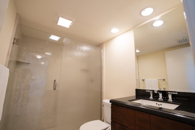 bathroom with vanity, an enclosed shower, and toilet