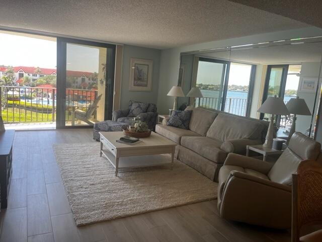 living room with floor to ceiling windows, hardwood / wood-style floors, and a textured ceiling