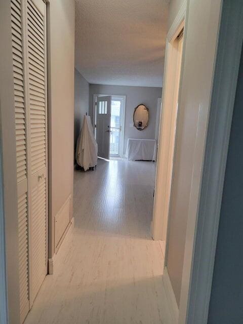 hallway with french doors and light hardwood / wood-style floors