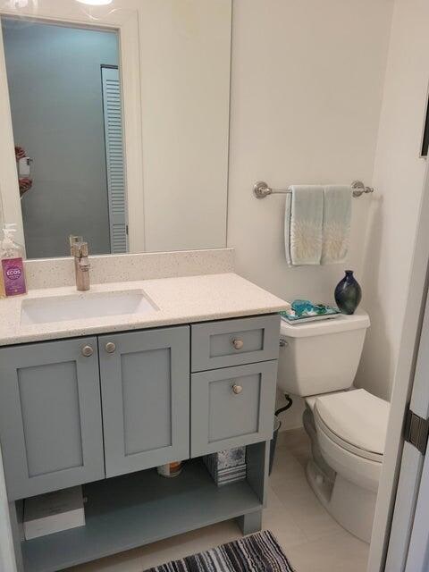 bathroom with tile patterned flooring, vanity, and toilet