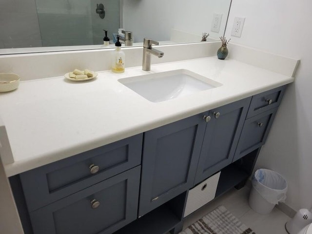 bathroom with a shower, vanity, and tile patterned floors