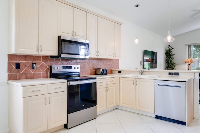 kitchen featuring backsplash, sink, stainless steel appliances, and decorative light fixtures