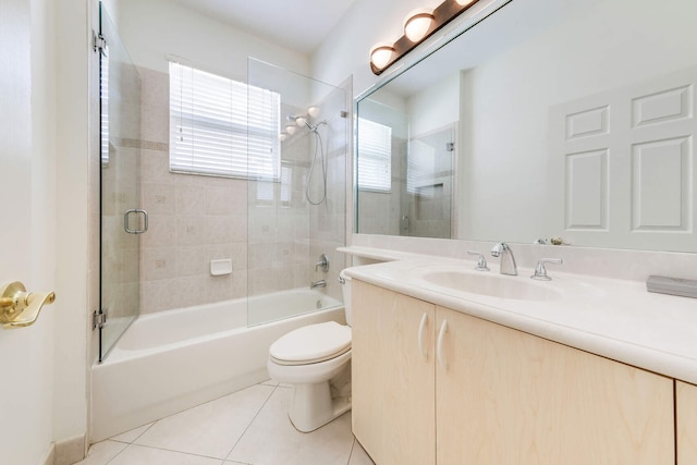 full bathroom featuring tile patterned flooring, vanity, toilet, and bath / shower combo with glass door