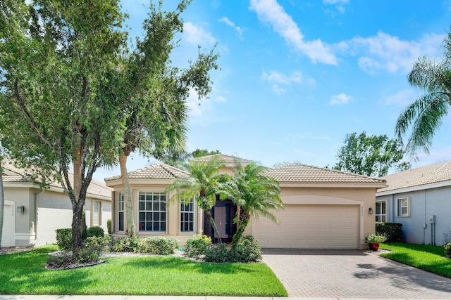 mediterranean / spanish-style home featuring a garage and a front yard