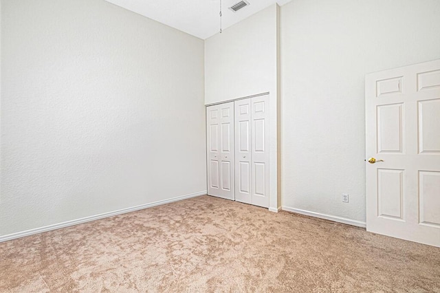 unfurnished bedroom featuring vaulted ceiling, carpet floors, and a closet