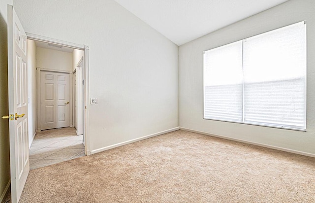 unfurnished room featuring light carpet and vaulted ceiling