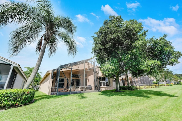 back of house featuring a yard and a lanai