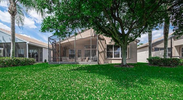 back of house featuring glass enclosure and a lawn