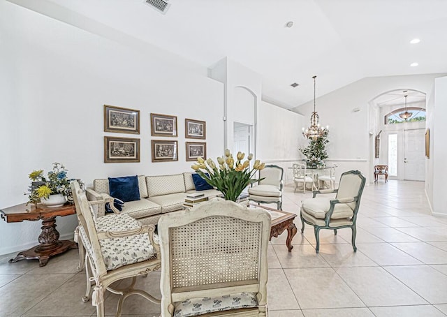 tiled living room with lofted ceiling and a notable chandelier