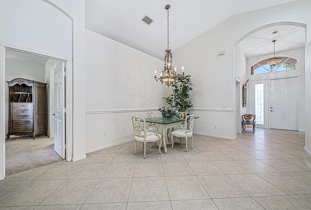 unfurnished dining area with light tile patterned floors, an inviting chandelier, and lofted ceiling