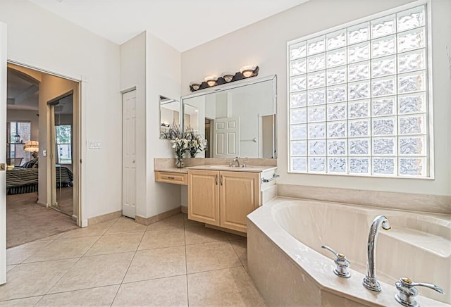 bathroom with vanity, tiled bath, and tile patterned floors