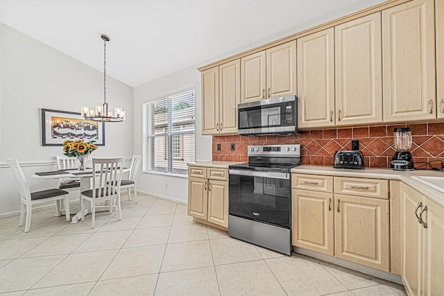 kitchen with decorative backsplash, light tile patterned flooring, stainless steel appliances, and vaulted ceiling