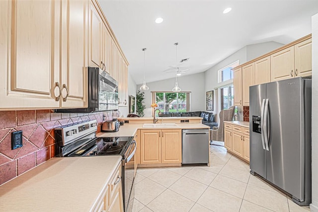 kitchen with sink, stainless steel appliances, tasteful backsplash, vaulted ceiling, and decorative light fixtures