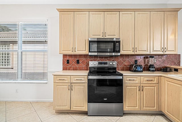 kitchen with decorative backsplash, light tile patterned floors, stainless steel appliances, and light brown cabinetry