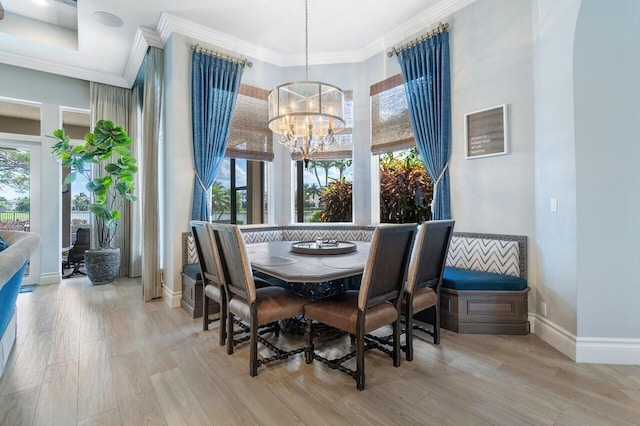 dining area featuring a chandelier, a healthy amount of sunlight, light hardwood / wood-style flooring, and crown molding