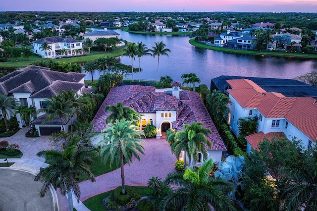 aerial view at dusk featuring a water view