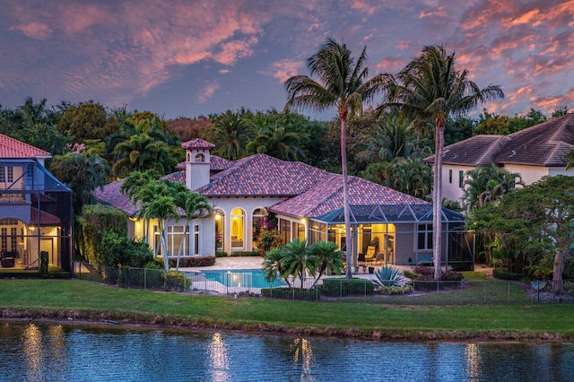 back house at dusk featuring a yard