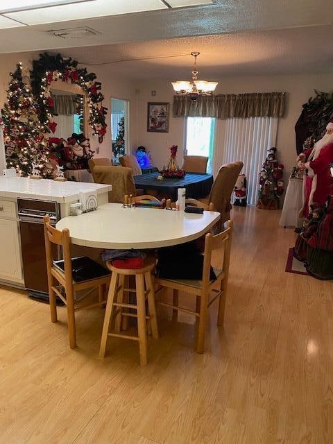 dining area with light hardwood / wood-style flooring and a notable chandelier