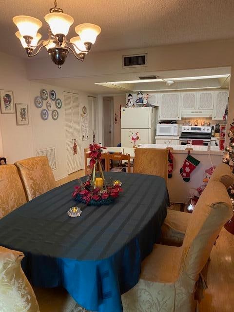 dining area with a notable chandelier and a textured ceiling