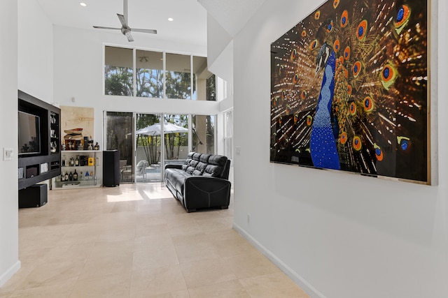 hallway with light tile flooring and a towering ceiling