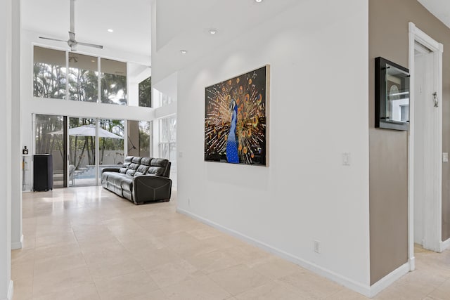 hall featuring a high ceiling and light tile floors