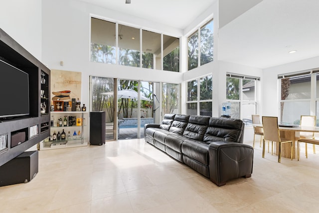 living room with a high ceiling and light tile floors