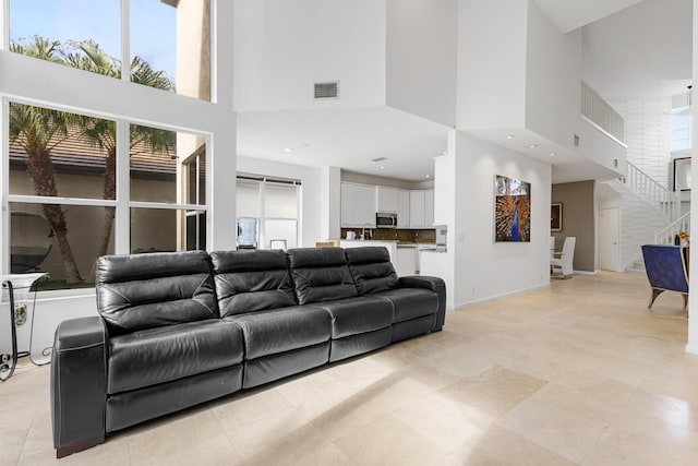 living room featuring light tile flooring and a high ceiling