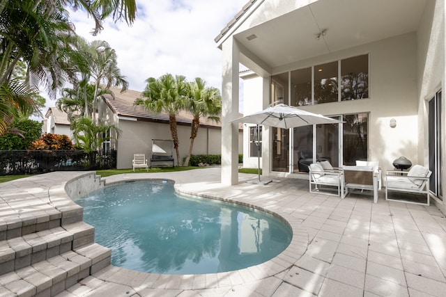 view of swimming pool featuring pool water feature and a patio area