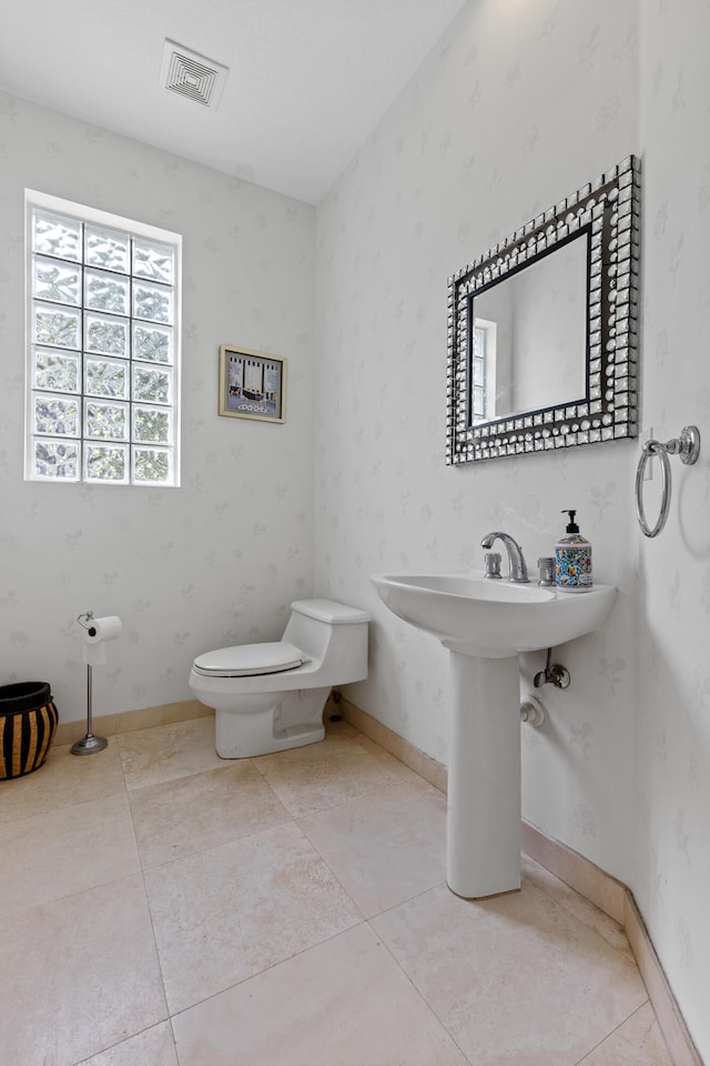 bathroom featuring toilet and tile floors