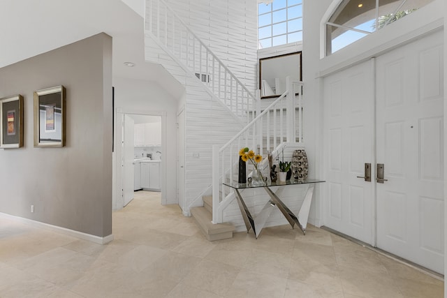 entryway featuring light tile floors and a towering ceiling