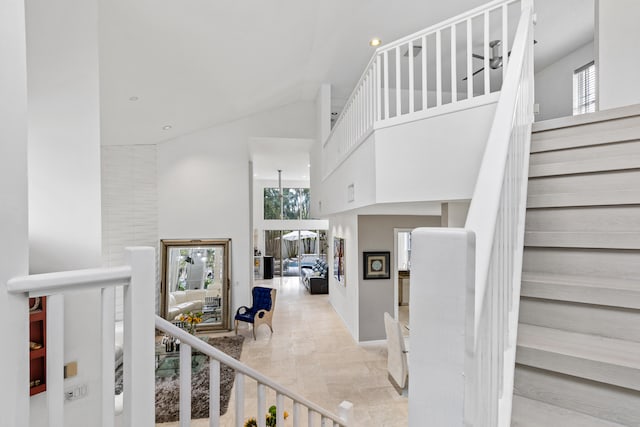 staircase featuring light tile flooring and a high ceiling