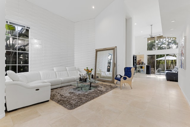 tiled living room featuring a high ceiling and ceiling fan