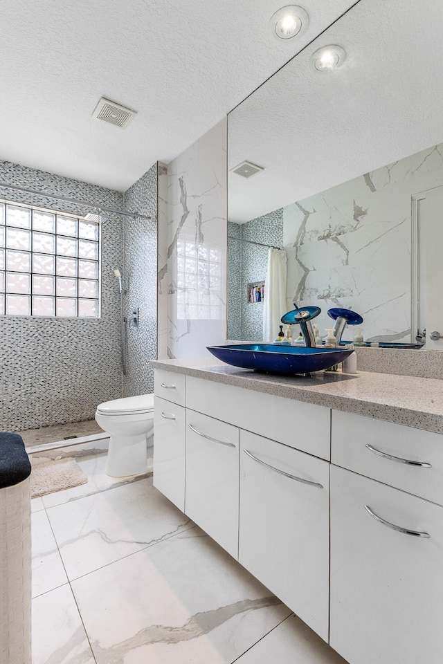 bathroom featuring toilet, tile flooring, a shower with curtain, a textured ceiling, and vanity