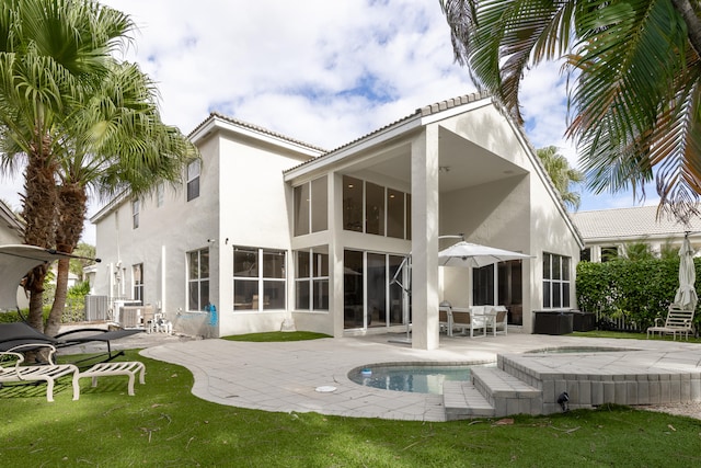 rear view of house with a yard, a patio area, a sunroom, and central AC