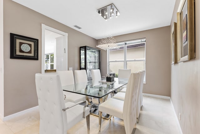 dining space featuring light tile floors and a notable chandelier