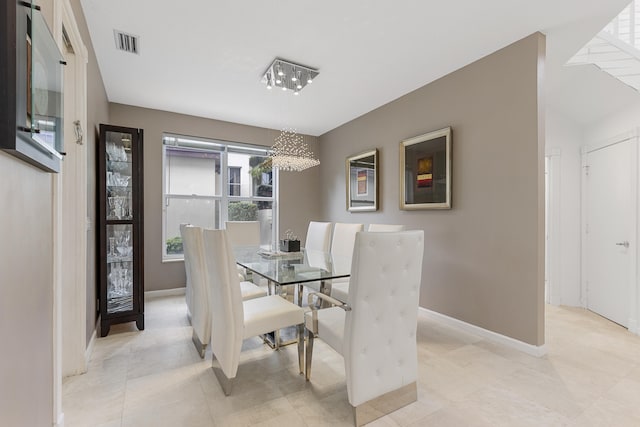 dining room featuring light tile floors and a notable chandelier