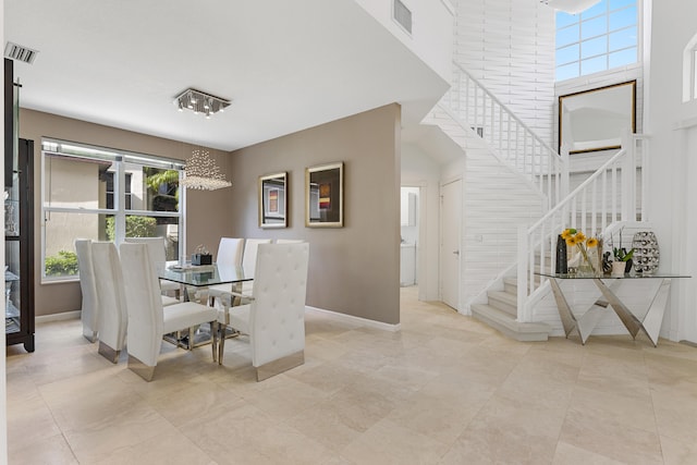 tiled dining space with a towering ceiling and a wealth of natural light