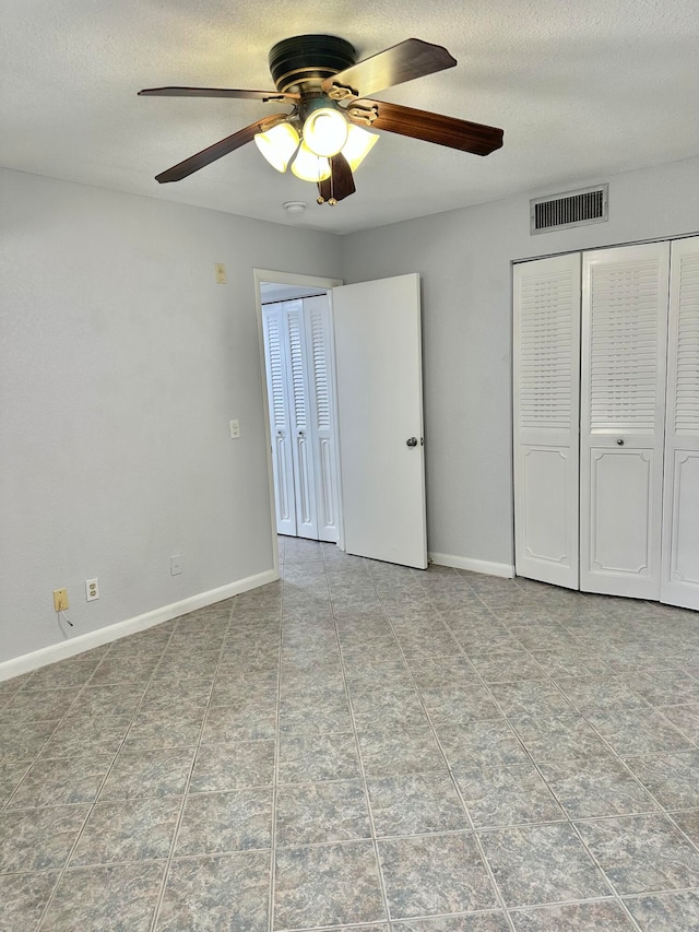 unfurnished bedroom with ceiling fan and light tile floors