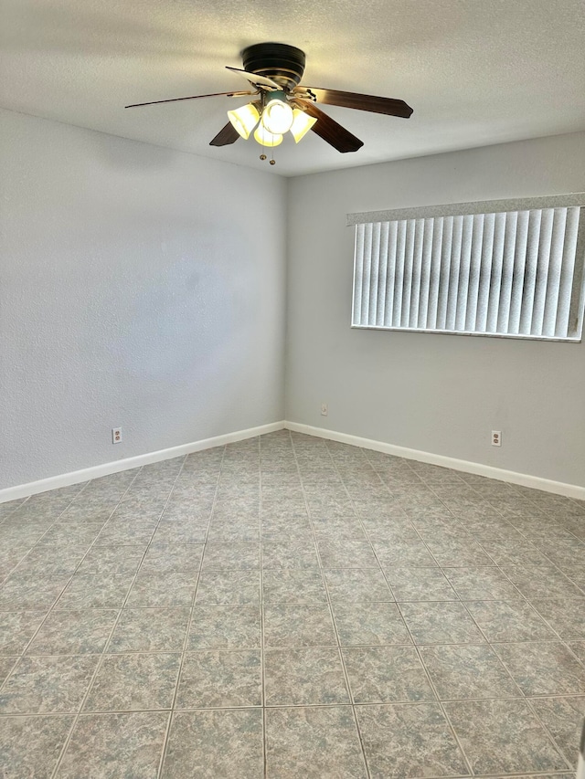 spare room featuring a textured ceiling, ceiling fan, and light tile floors