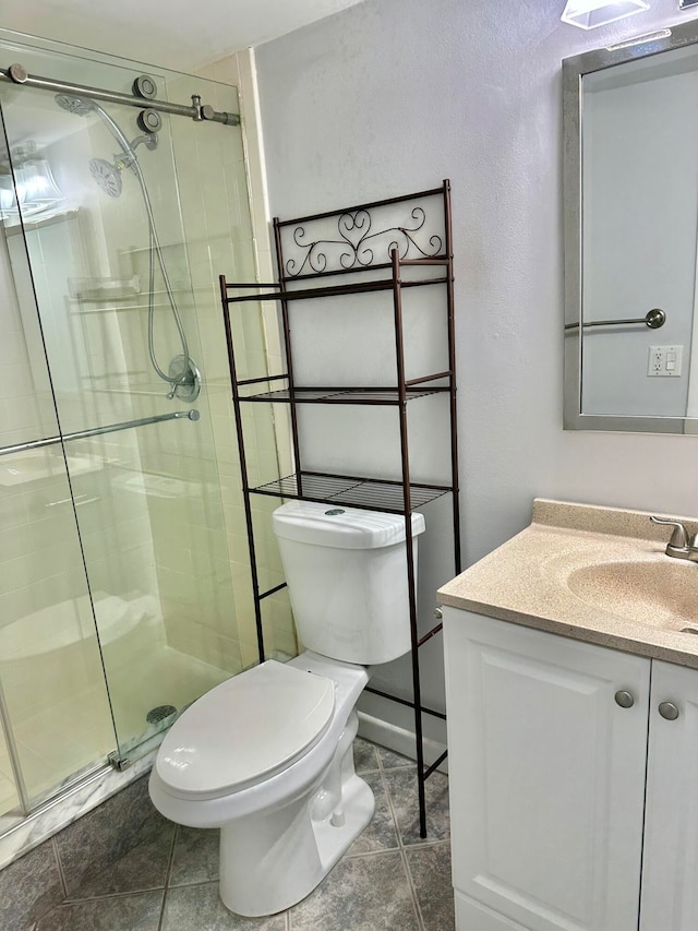 bathroom featuring tile floors, vanity, toilet, and a shower with shower door