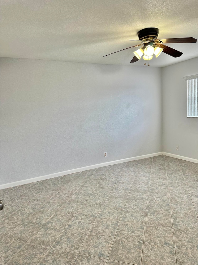 spare room featuring ceiling fan and light tile floors