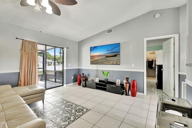 tiled living room with ceiling fan and lofted ceiling