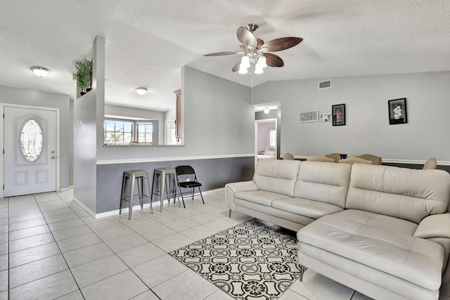 tiled living room featuring ceiling fan and a textured ceiling