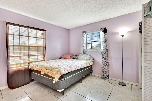 tiled bedroom featuring a textured ceiling