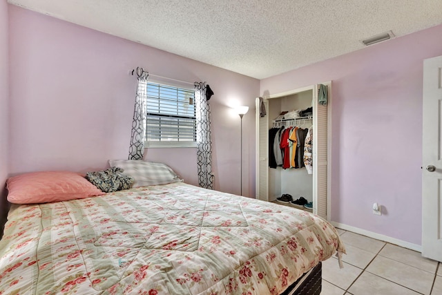 tiled bedroom featuring a closet and a textured ceiling