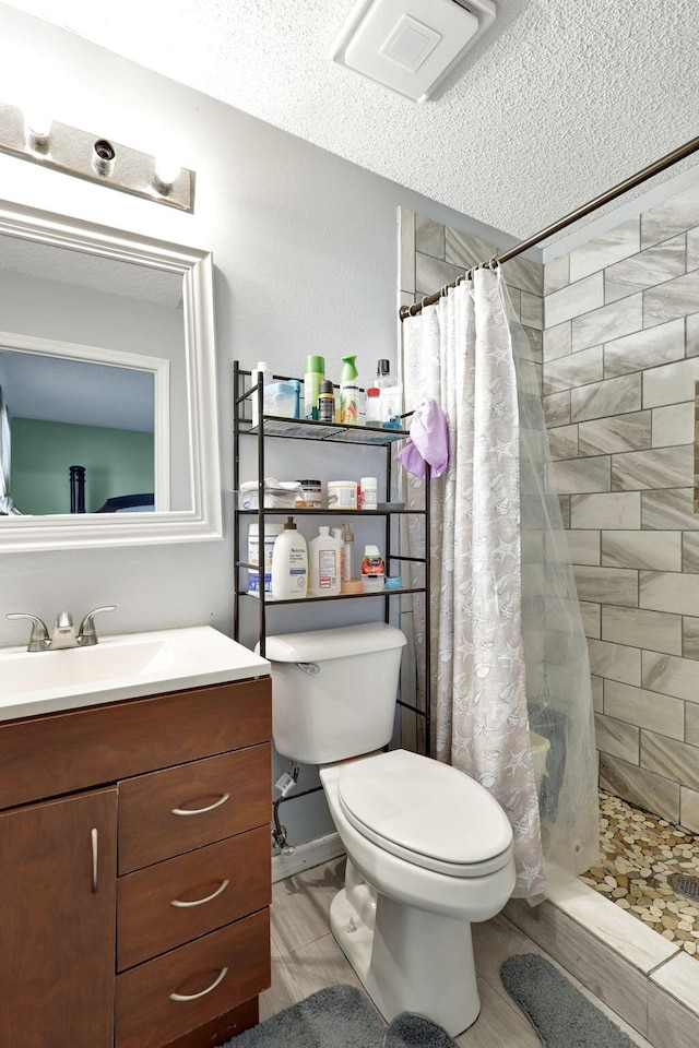 bathroom with a shower with curtain, a textured ceiling, tile floors, toilet, and vanity