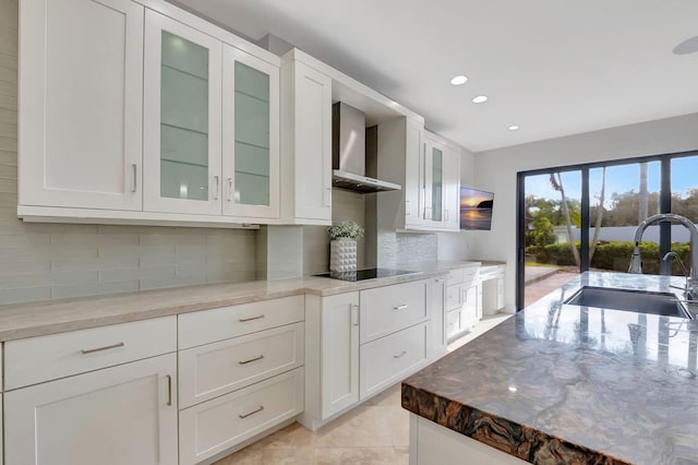 kitchen with light stone countertops, sink, and white cabinets